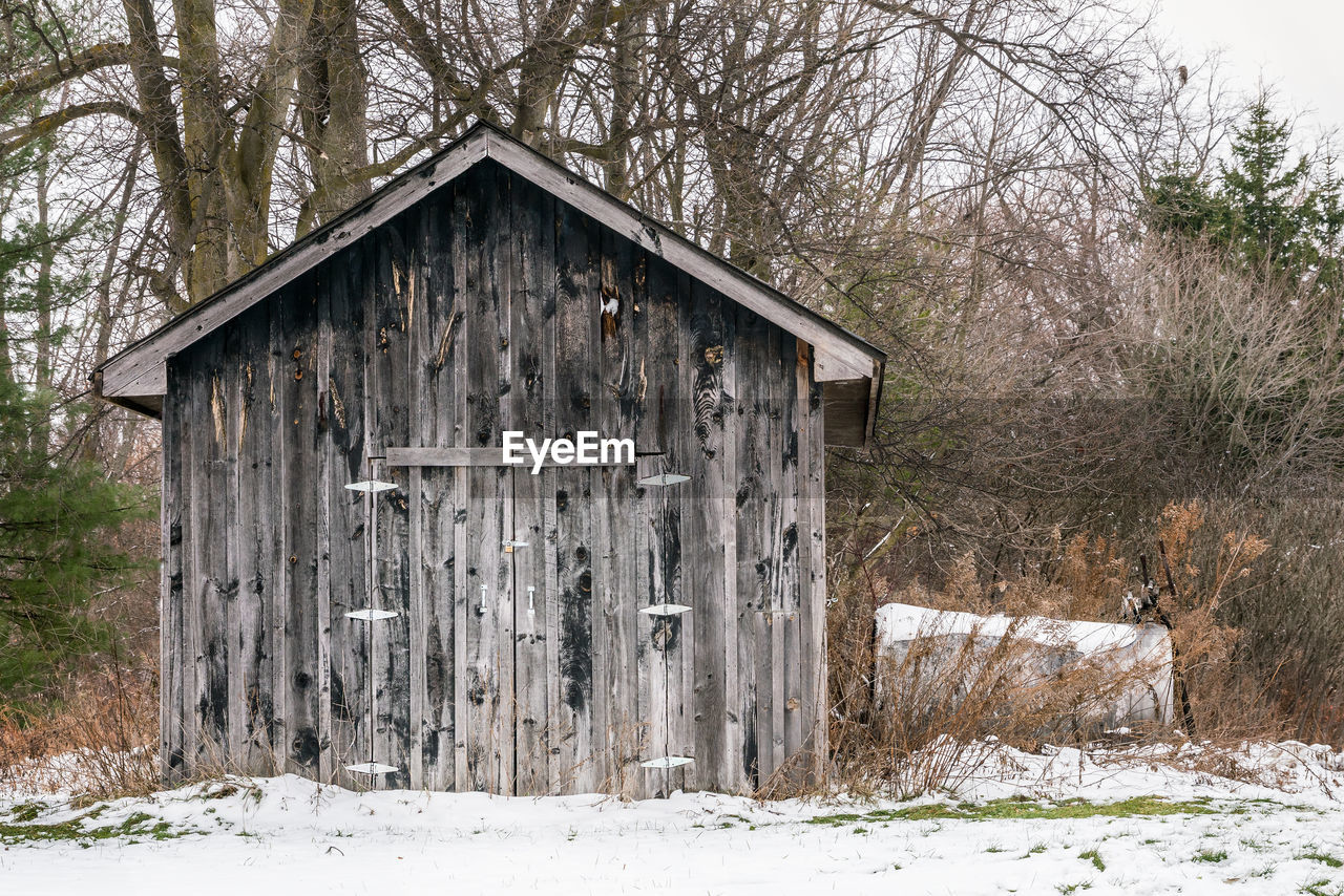 Abandoned cottage on snow covered field