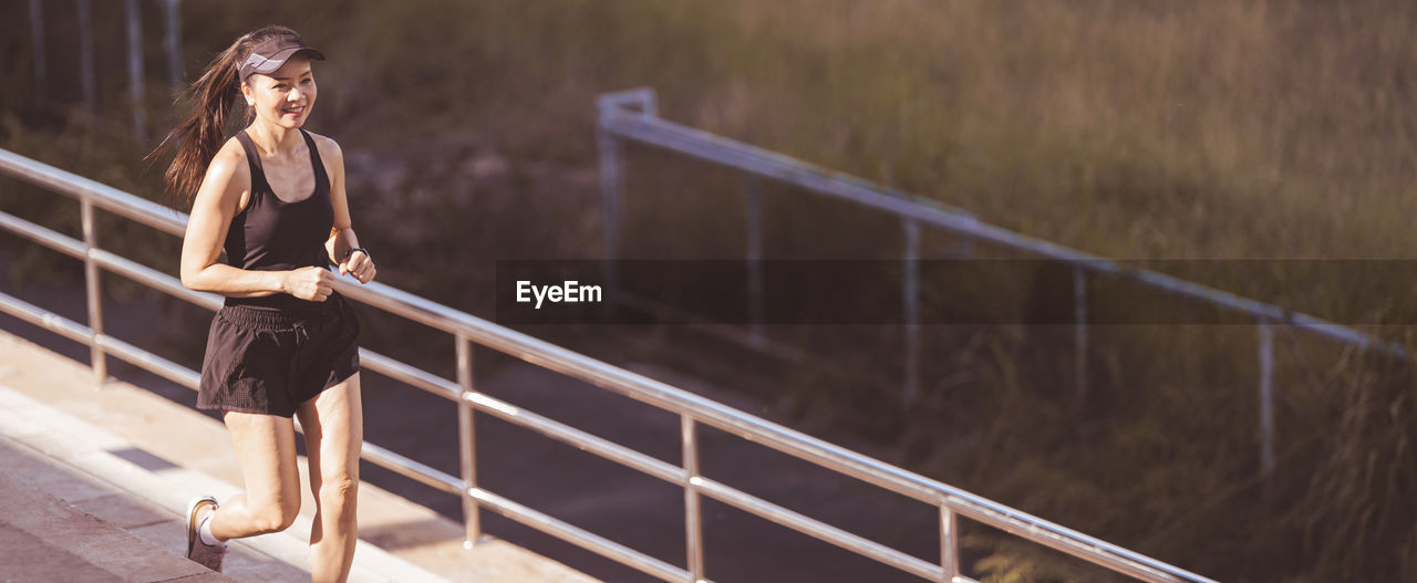 Woman standing on footbridge