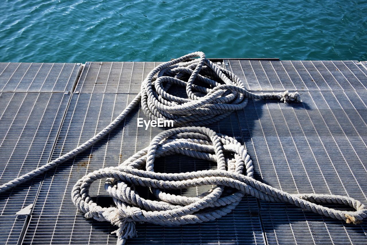 High angle view of ropes on metal grate