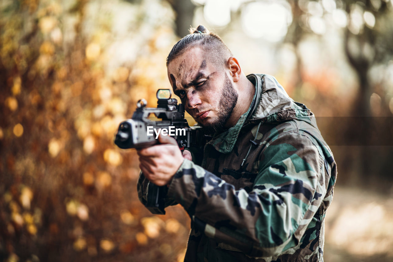 Man holding camera while standing outdoors