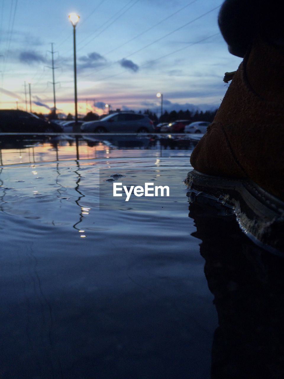 REFLECTION OF MAN IN CAR ON WATER