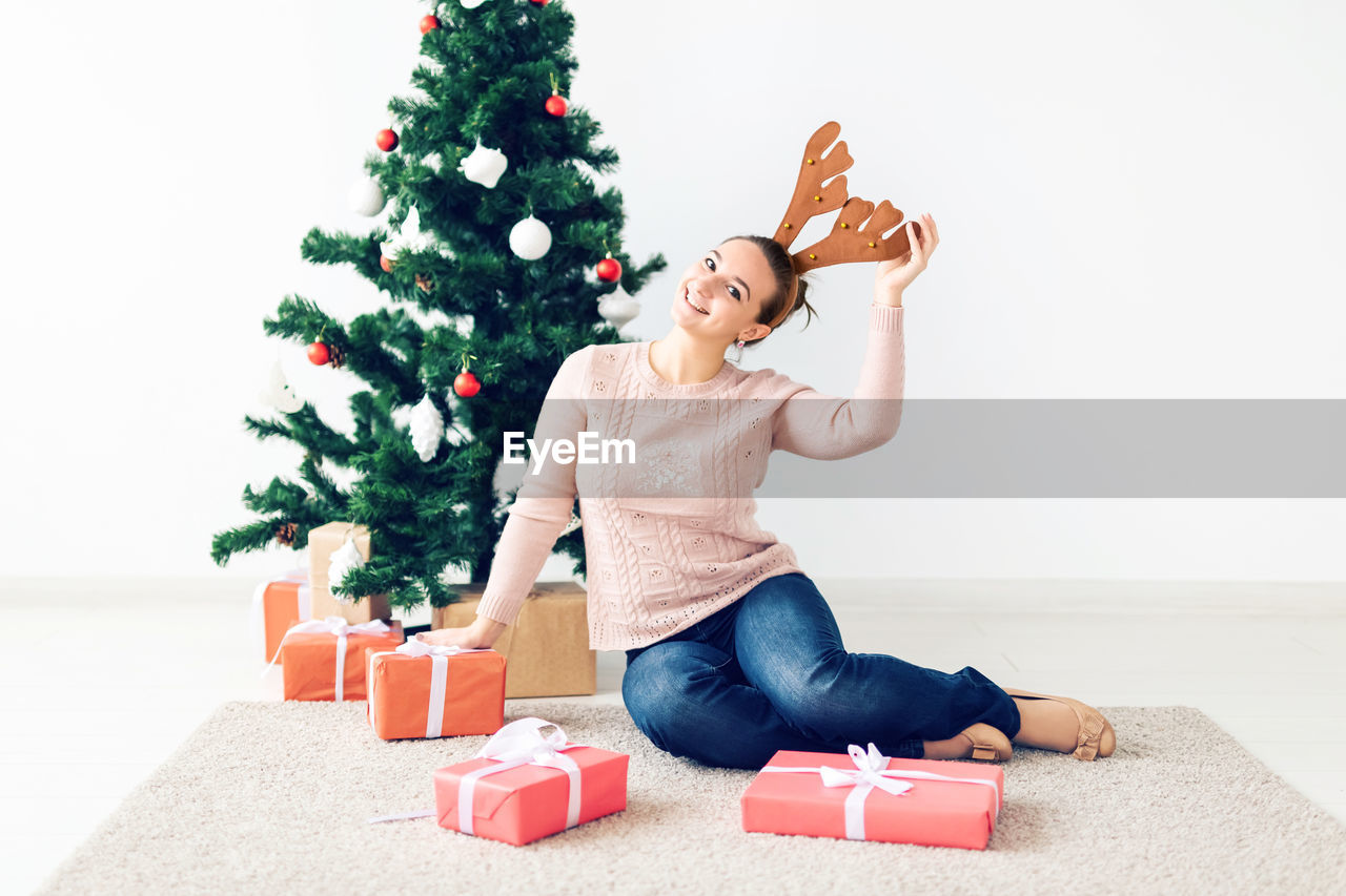 YOUNG WOMAN WITH CHRISTMAS TREE IN BOX