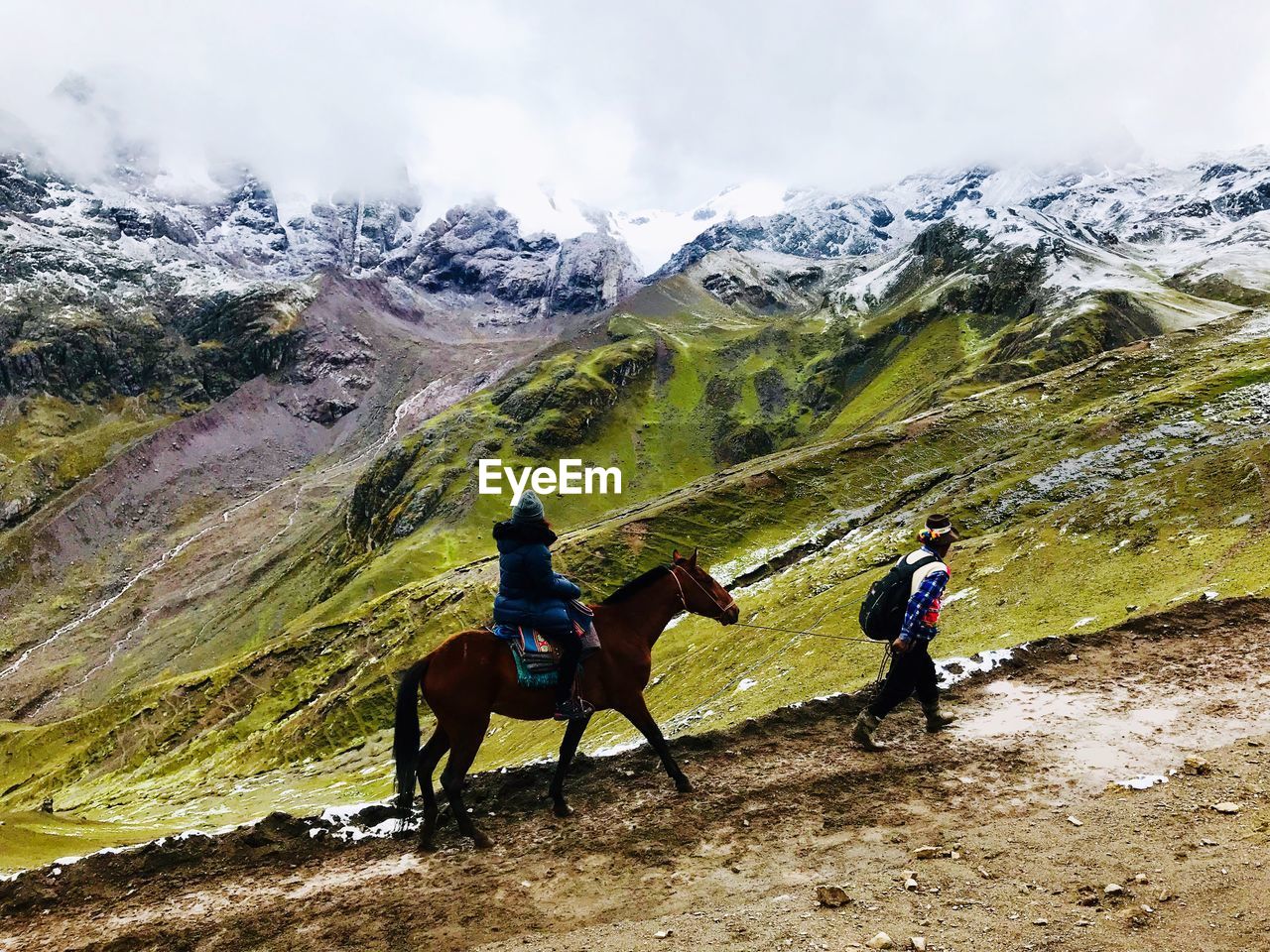 MEN RIDING HORSE ON MOUNTAIN