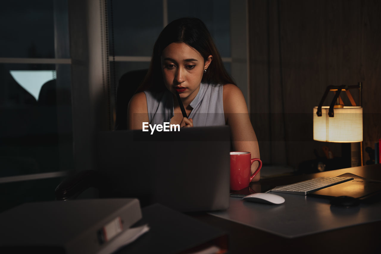 Depressed girl using laptop sitting at home