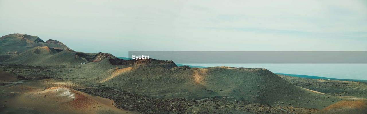 Scenic view of sea and mountains against sky