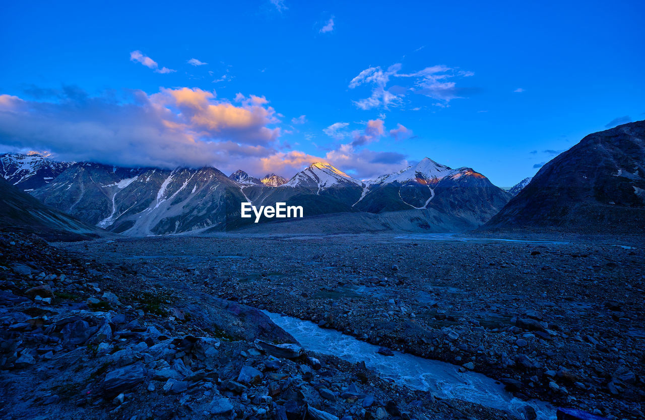 Scenic view of snowcapped mountains against blue sky