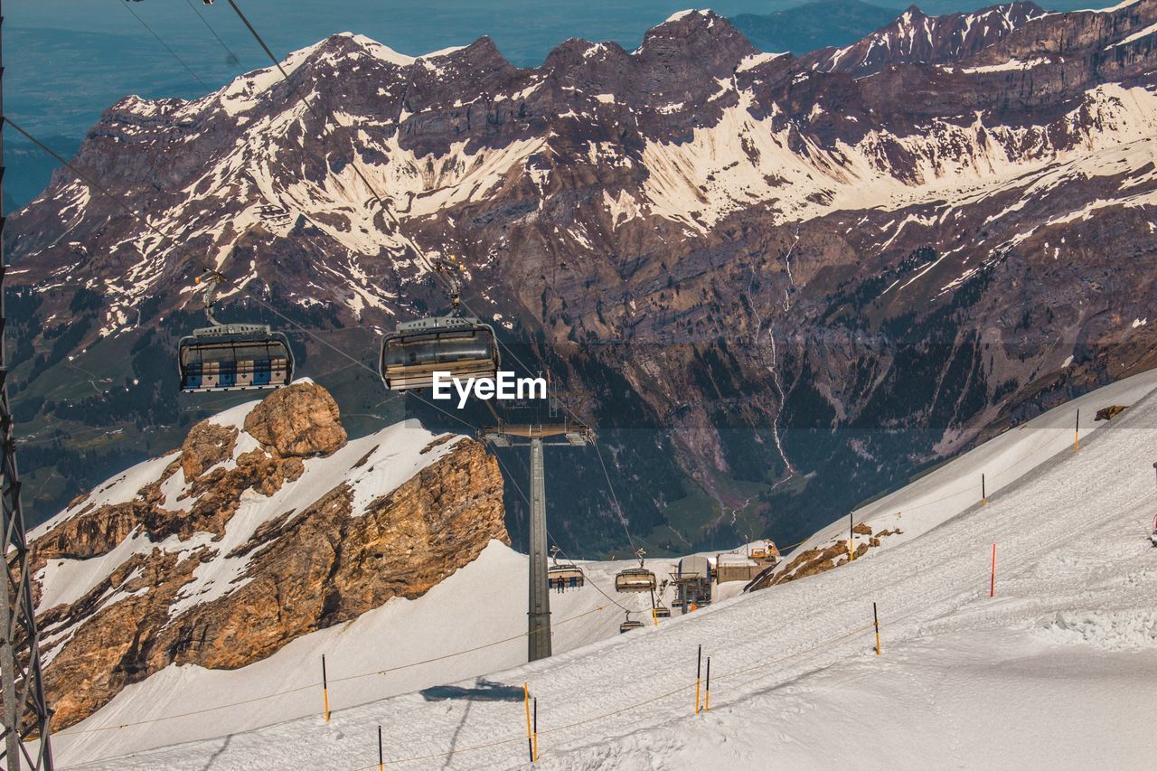 Overhead cable car against snowcapped mountains during winter