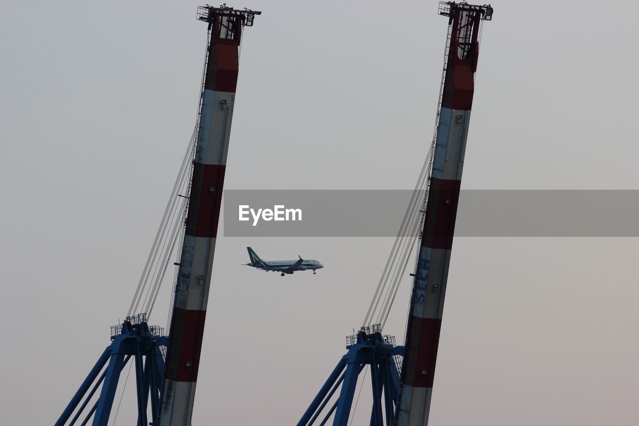 LOW ANGLE VIEW OF CRANES AGAINST SKY