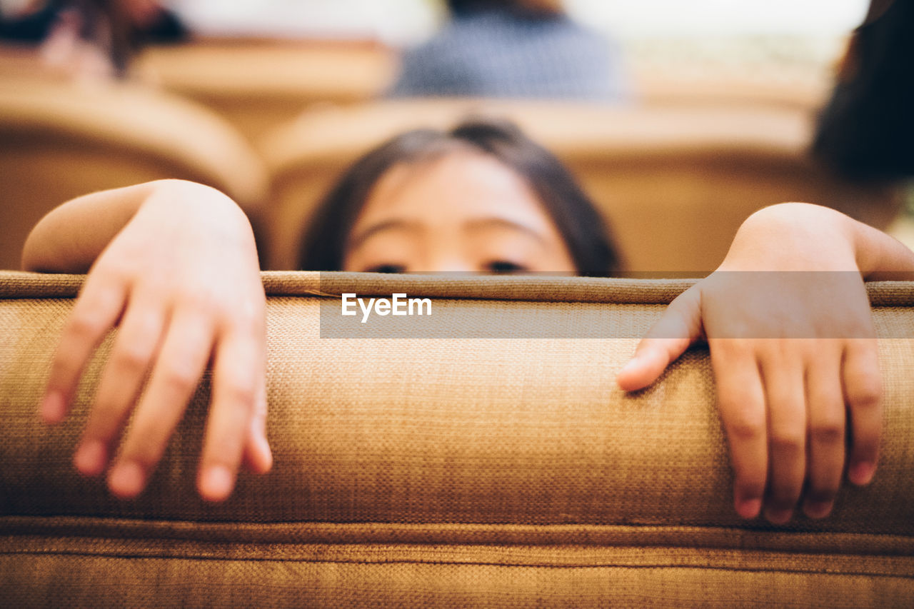 Close-up of girl hands on sofa at home