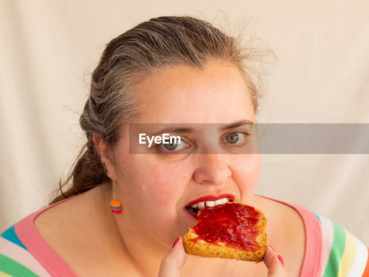 CLOSE-UP PORTRAIT OF A WOMAN EATING FOOD