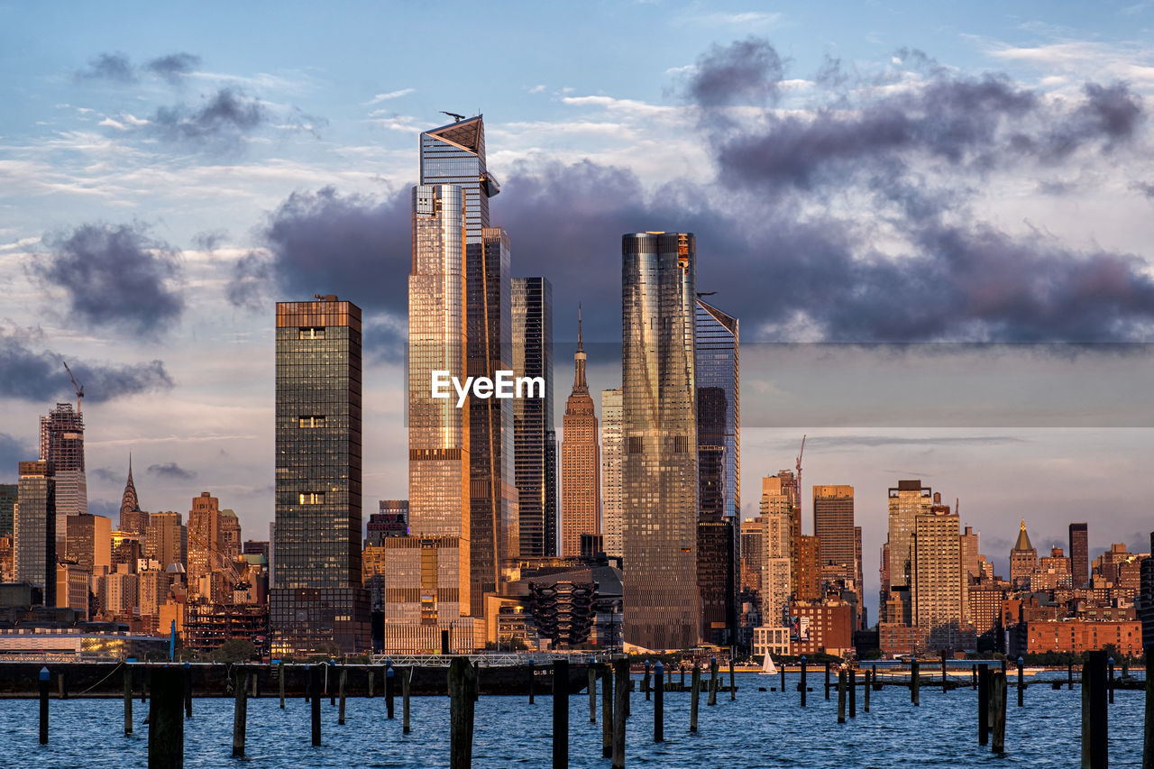 Modern buildings by sea against sky in city