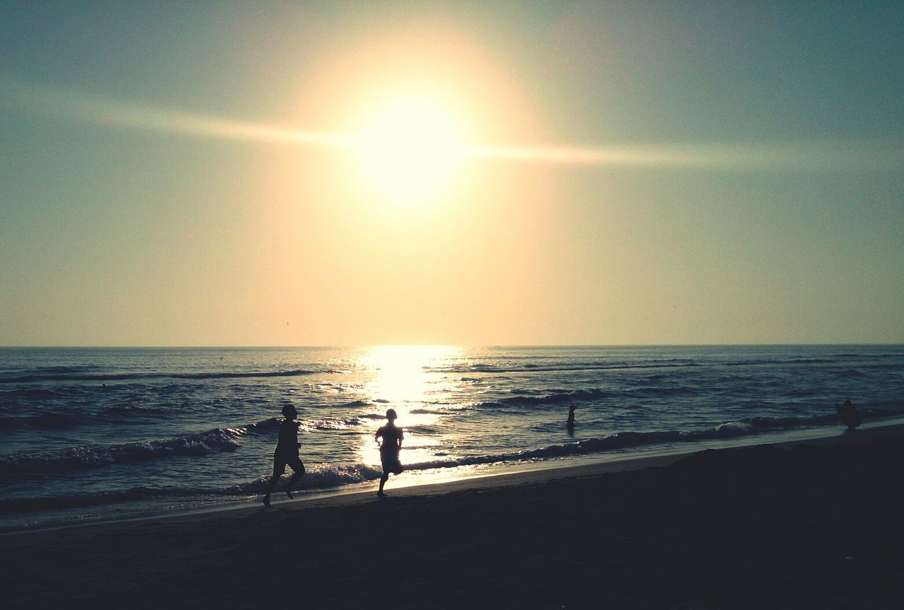 Scenic view of sea against bright sun