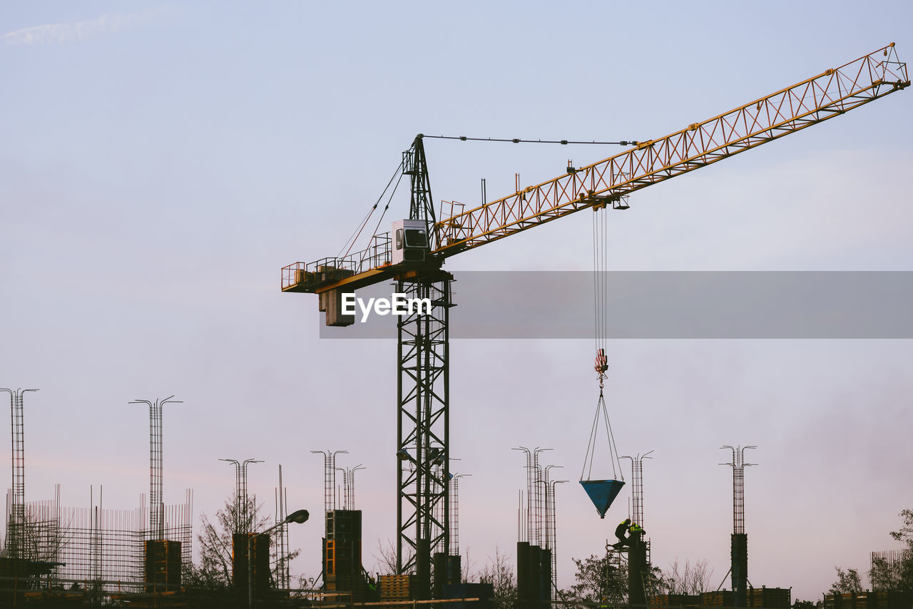 Low angle view of crane against sky