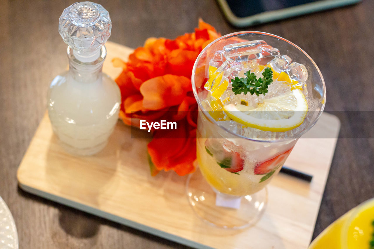 HIGH ANGLE VIEW OF JUICE AND GLASS ON TABLE