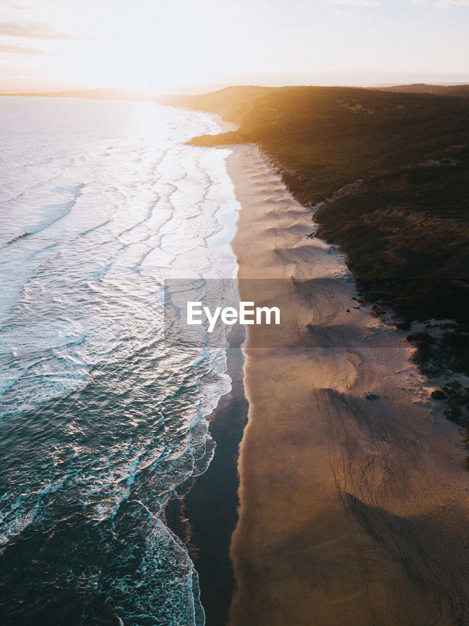 Aerial view of beach against sky during sunset