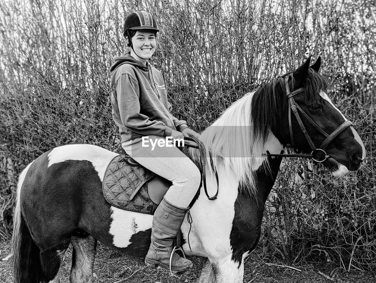 Portrait of young woman sat on her horse 