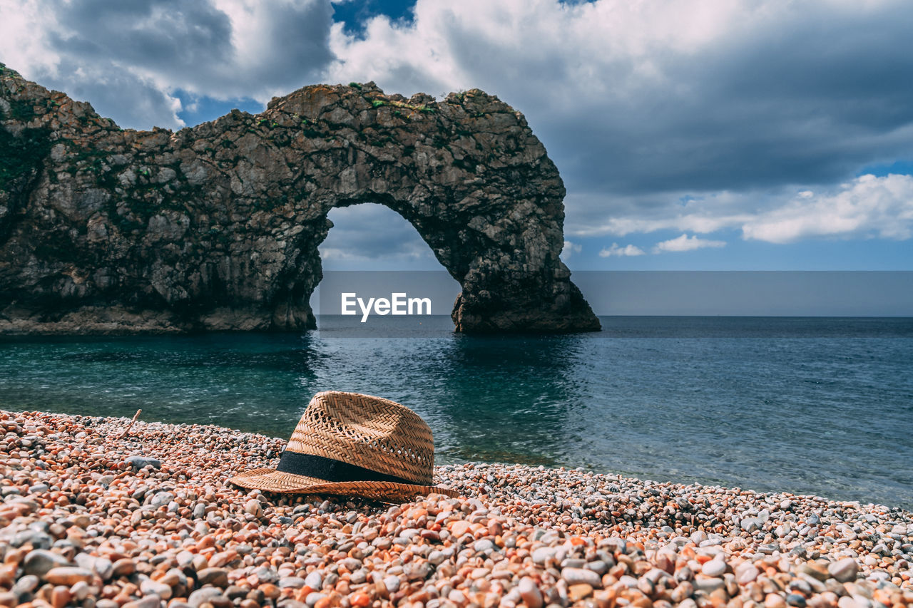 Rock formation on sea shore against sky