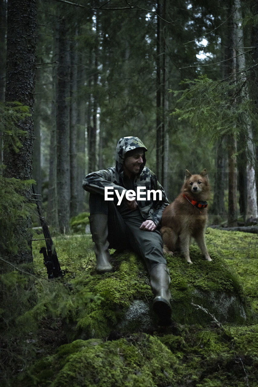 Hunter with dog in forest