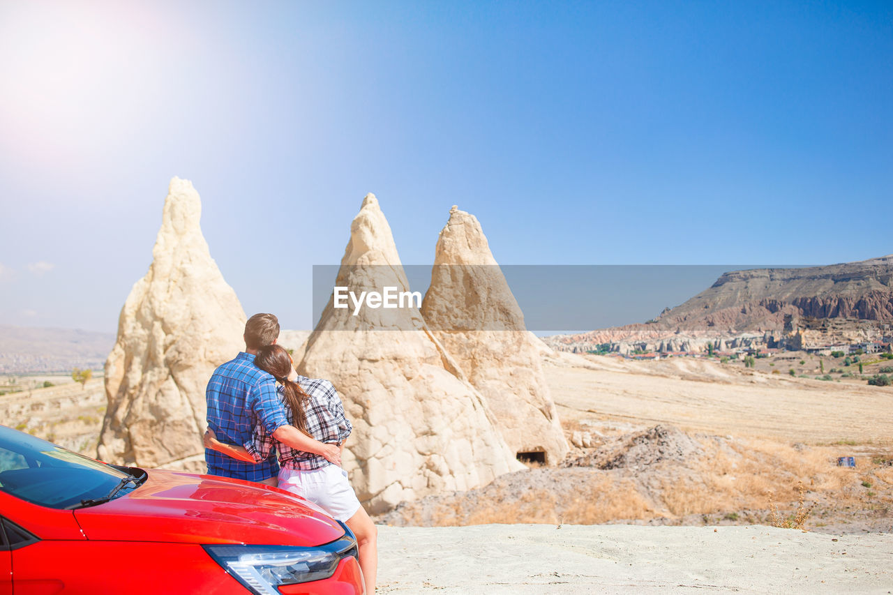 rear view of man sitting on rock formations