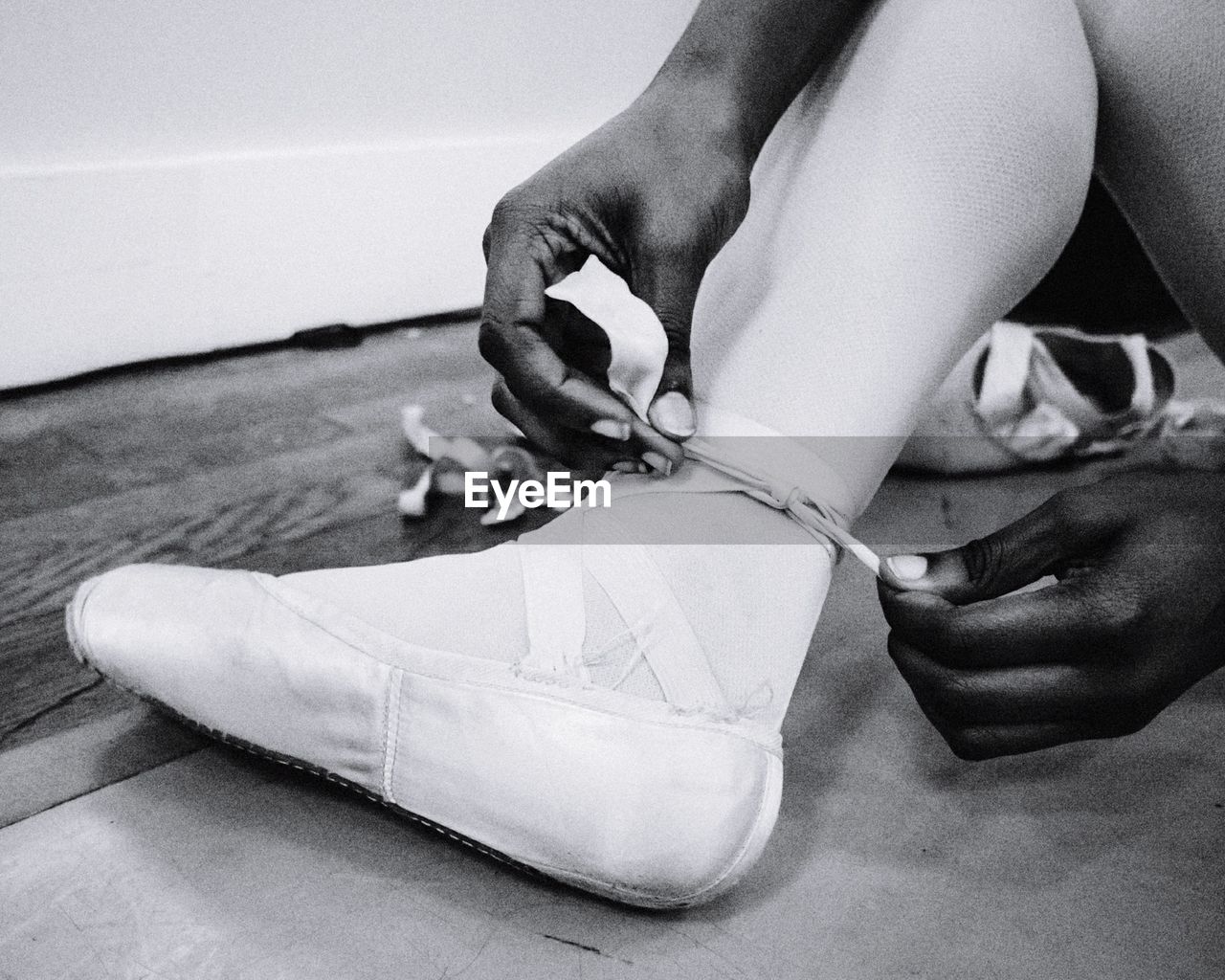 Low section of ballet dancer wearing shoe at studio