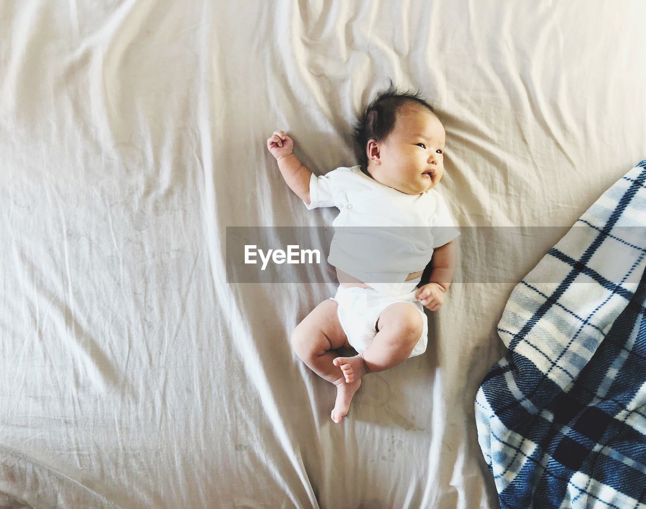 Directly above shot of baby girl lying on bed