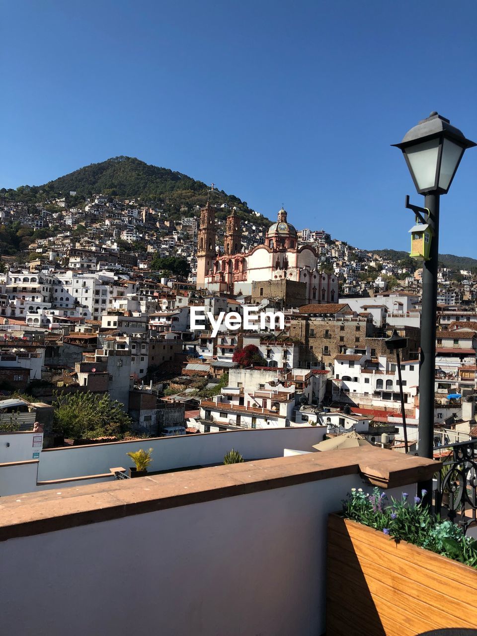 HIGH ANGLE VIEW OF CITYSCAPE BY SEA AGAINST CLEAR SKY