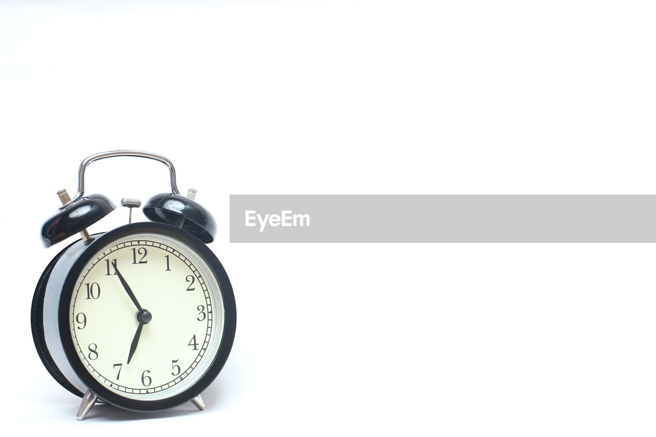 Close-up of alarm clock on white background