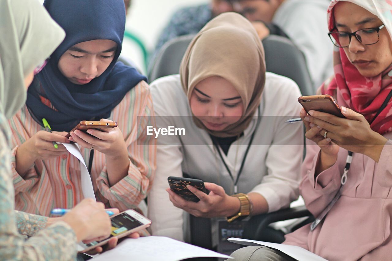 Females wearing hijab using smart phones