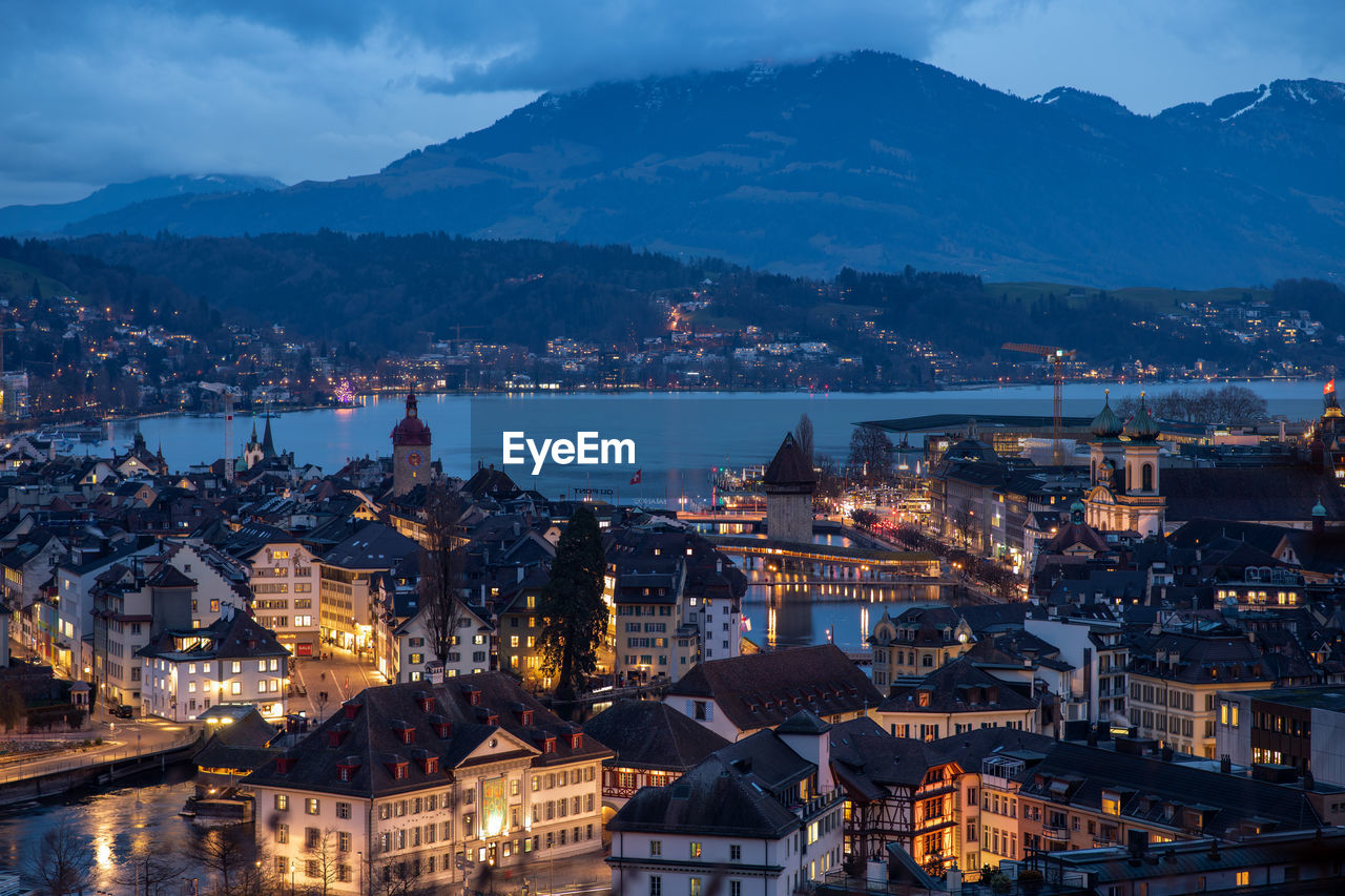 High angle view of illuminated city against sky at dusk