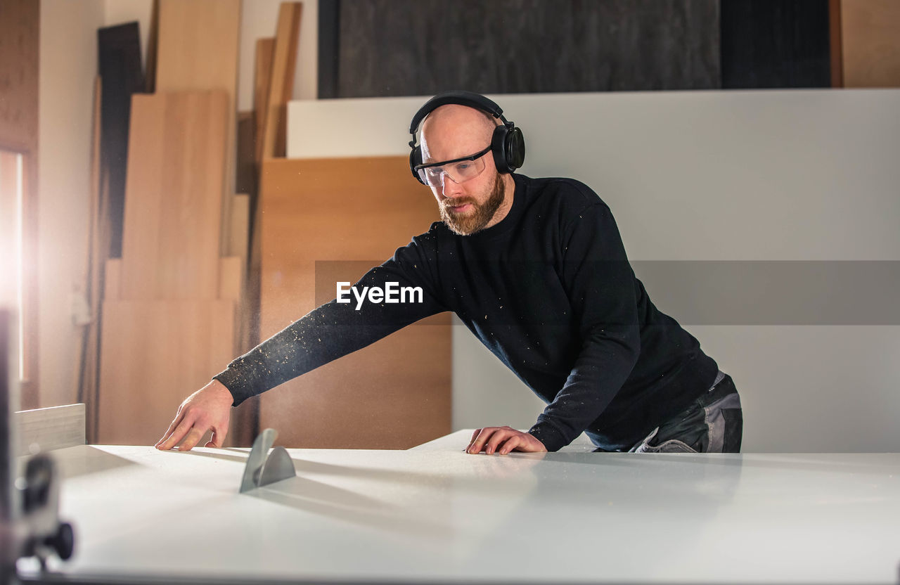 MAN WORKING ON TABLE AT HOME