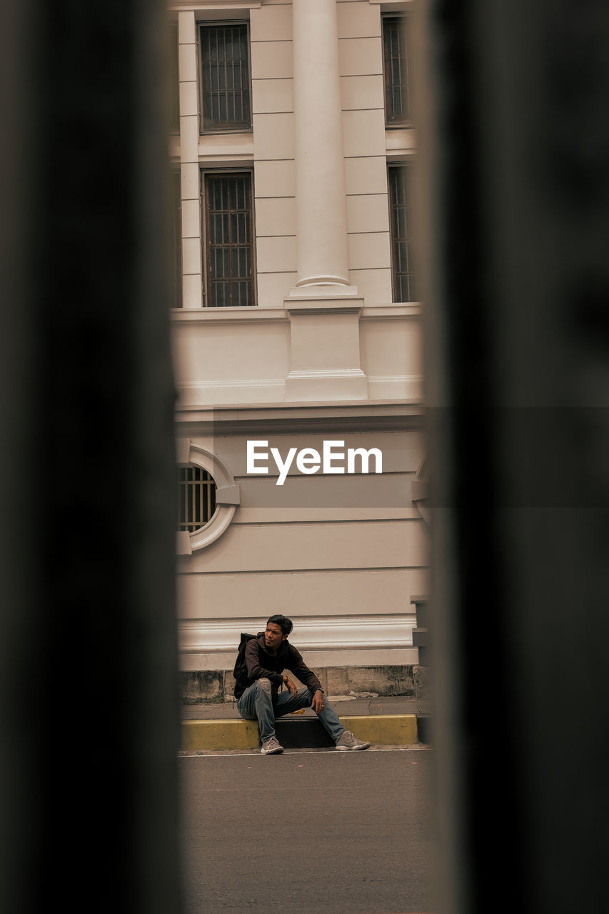 Rear view of woman standing in front of building