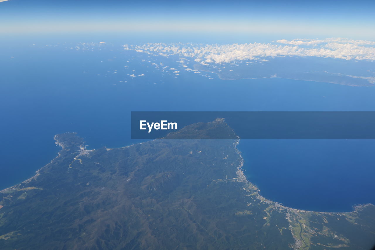 AERIAL VIEW OF SEA BY MOUNTAIN AGAINST SKY