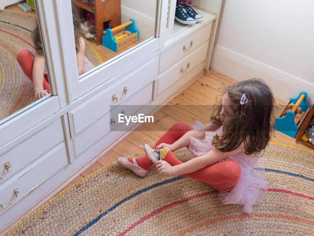 High angle view of girl wearing shoe at home