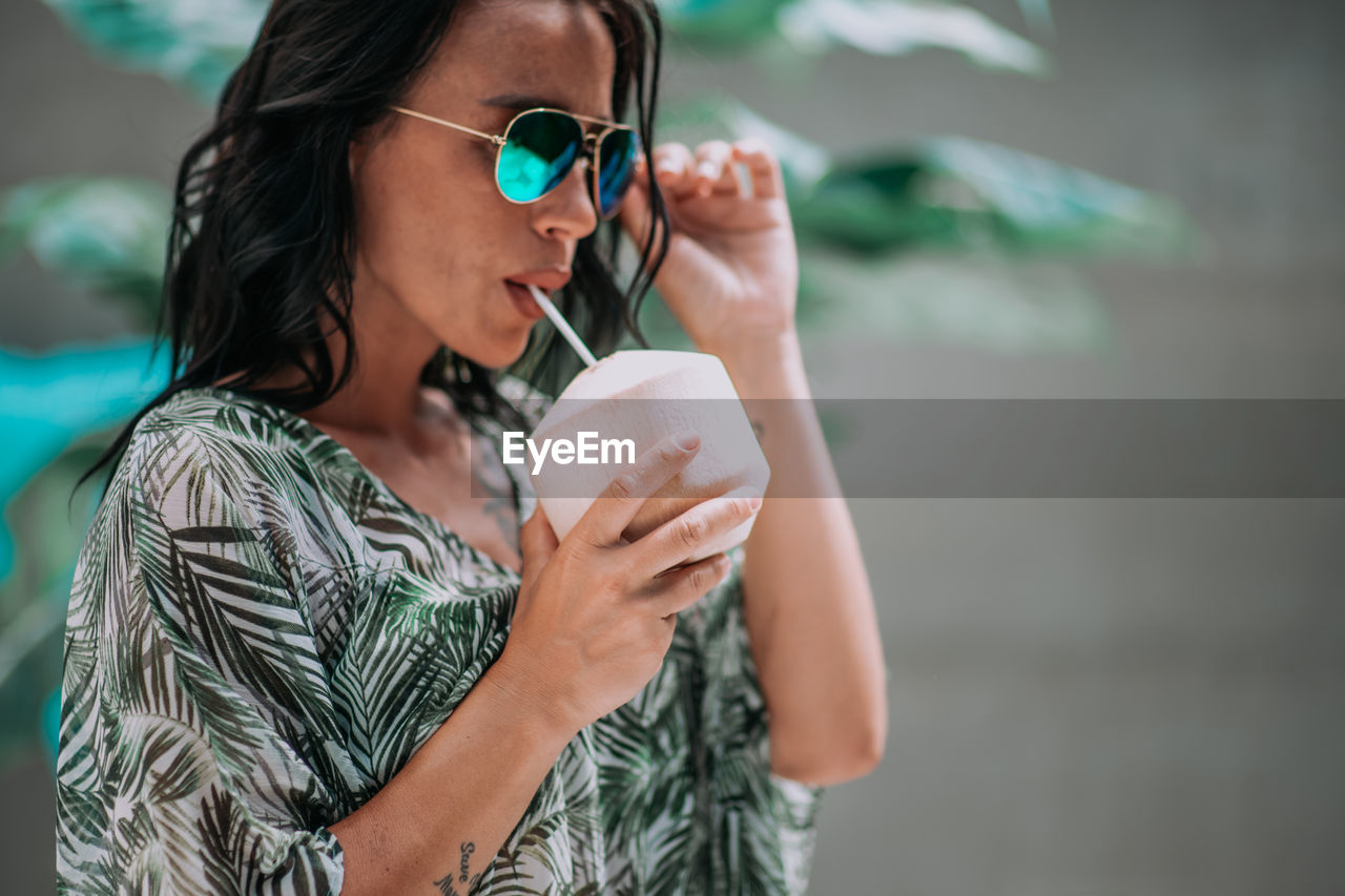 Young woman drinking water from coffee