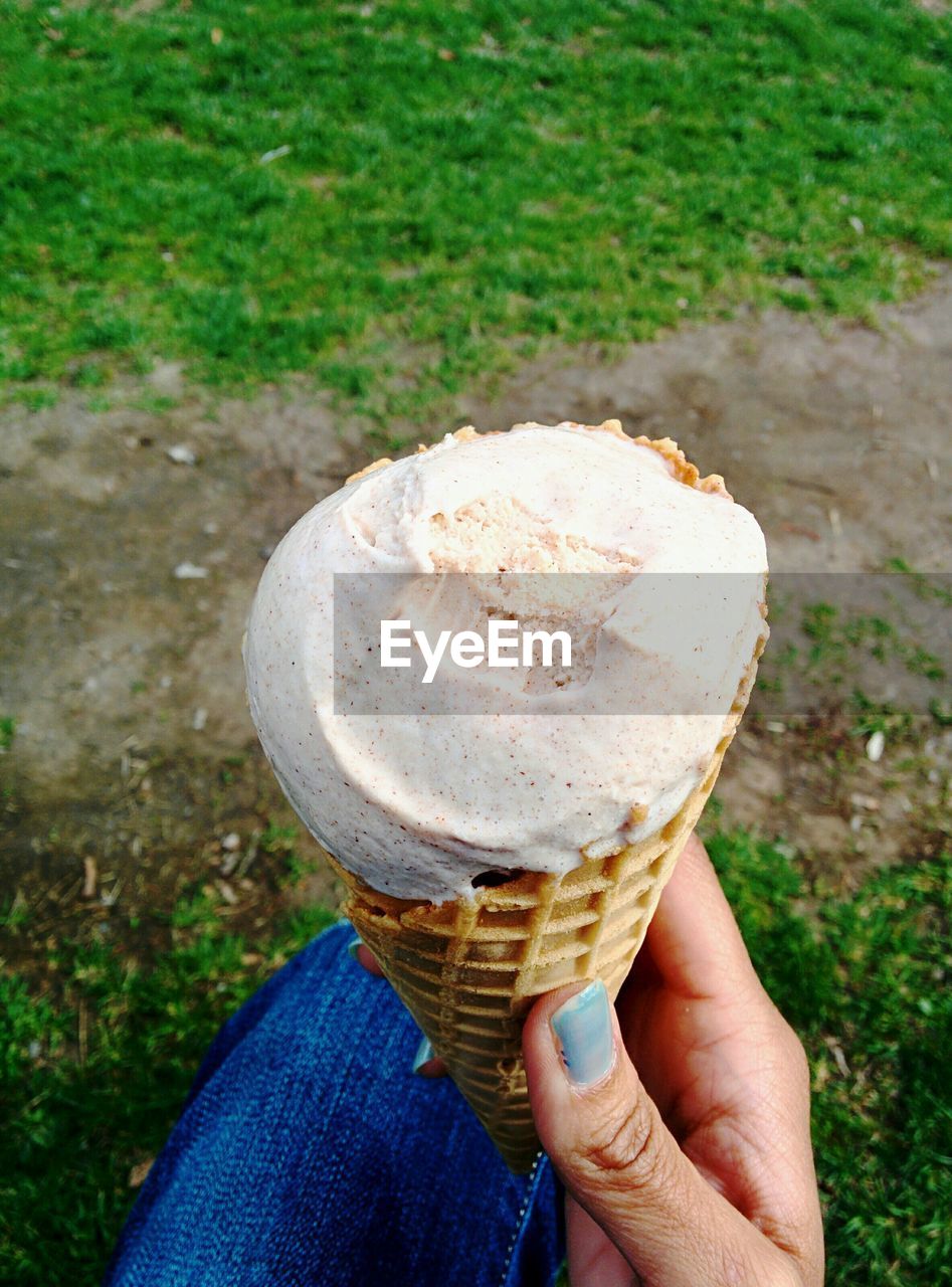 Close-up of woman holding vanilla ice cream cone