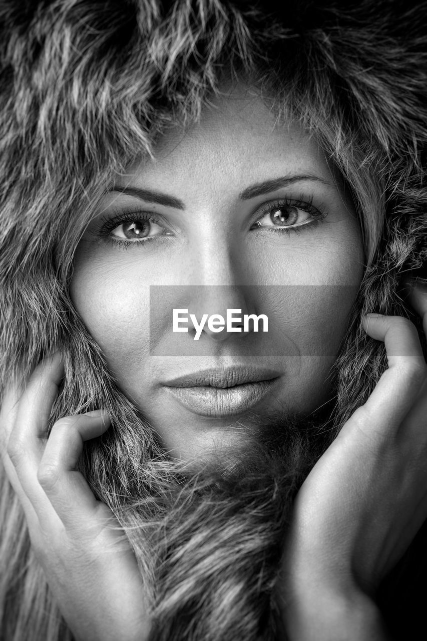 Close-up portrait of beautiful woman wearing fur hood