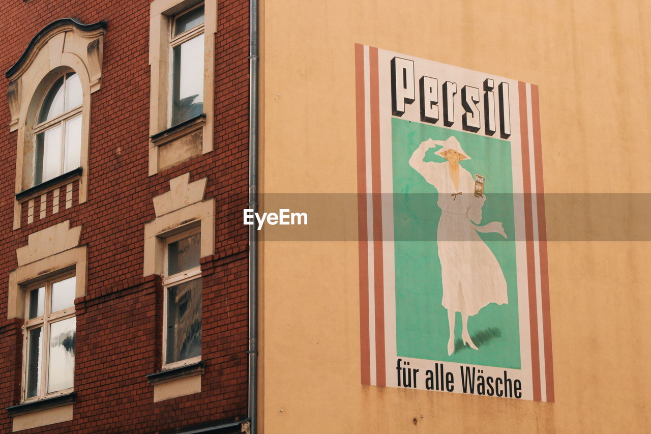 LOW ANGLE VIEW OF SIGN BY BUILDING