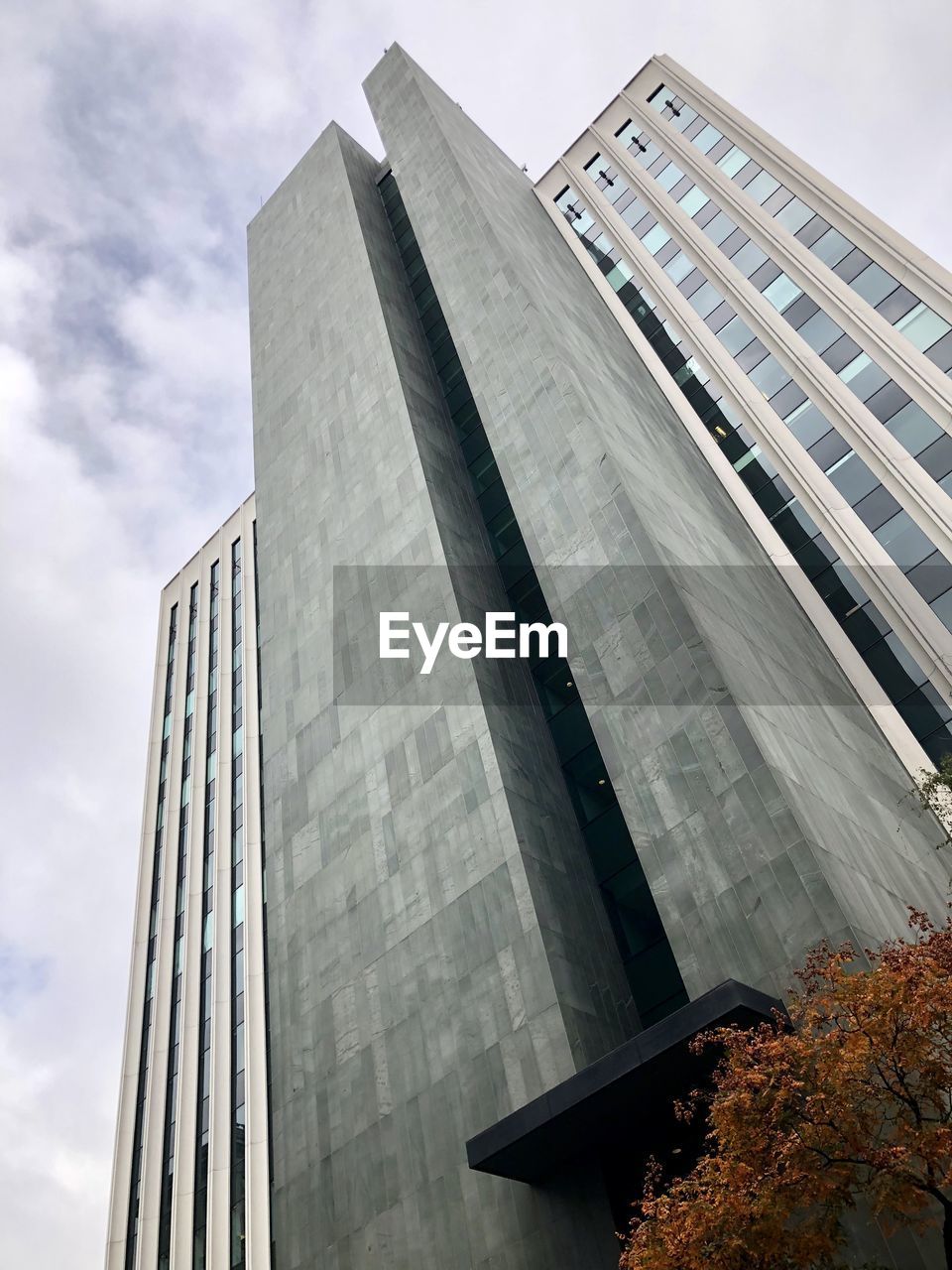 Low angle view of modern building against cloudy sky