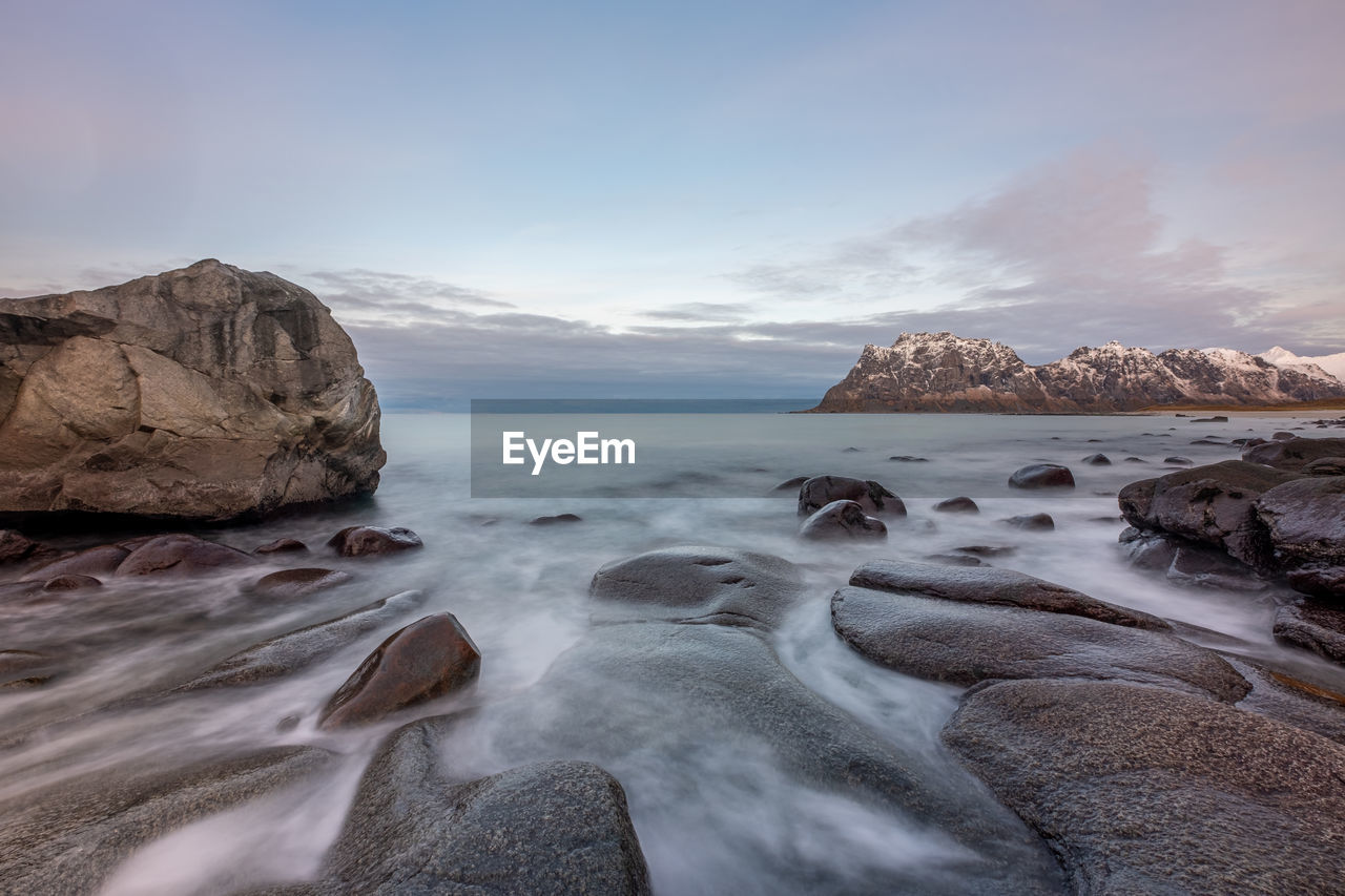 SCENIC VIEW OF ROCKS ON SHORE AGAINST SKY