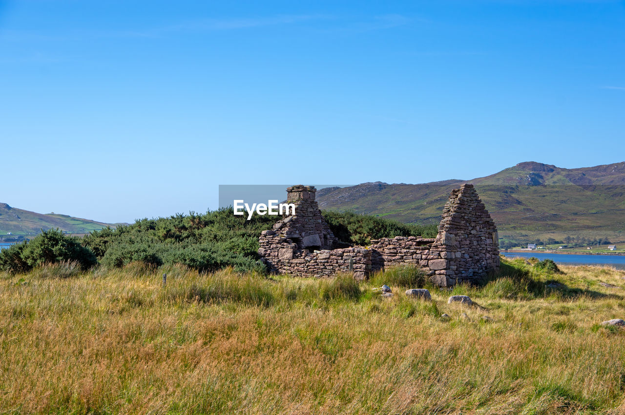 STONE WALL ON FIELD AGAINST CLEAR SKY