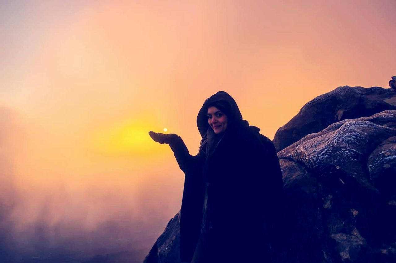 Woman photographing at sunset