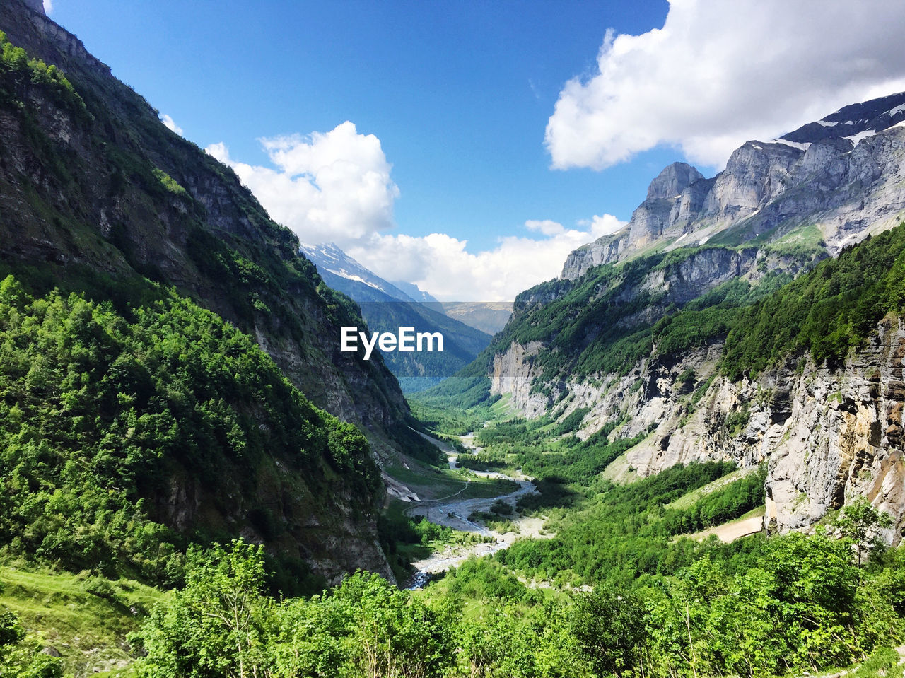 Scenic view of valley and mountains against sky