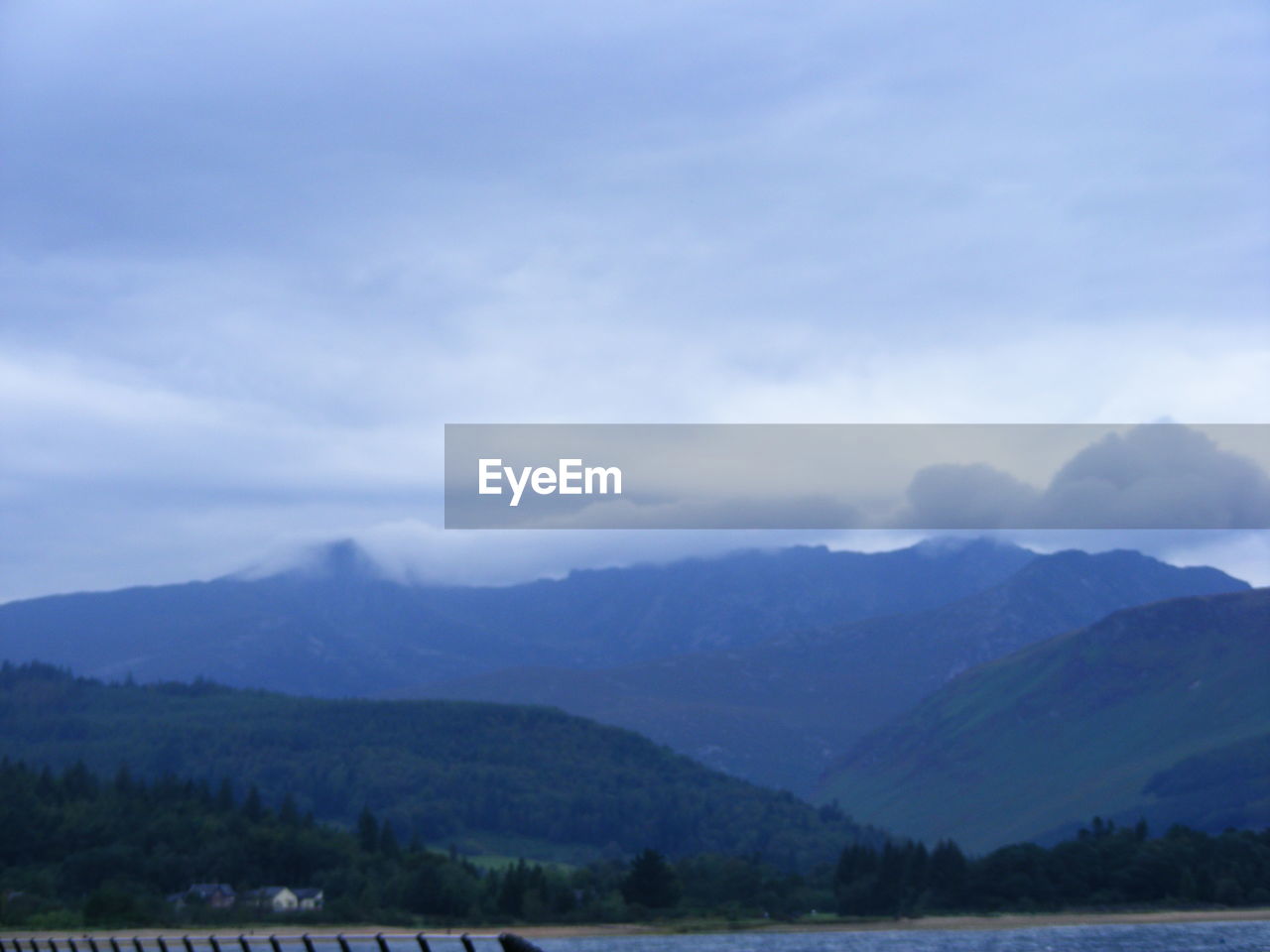 SCENIC VIEW OF MOUNTAINS AGAINST STORM CLOUDS OVER LANDSCAPE