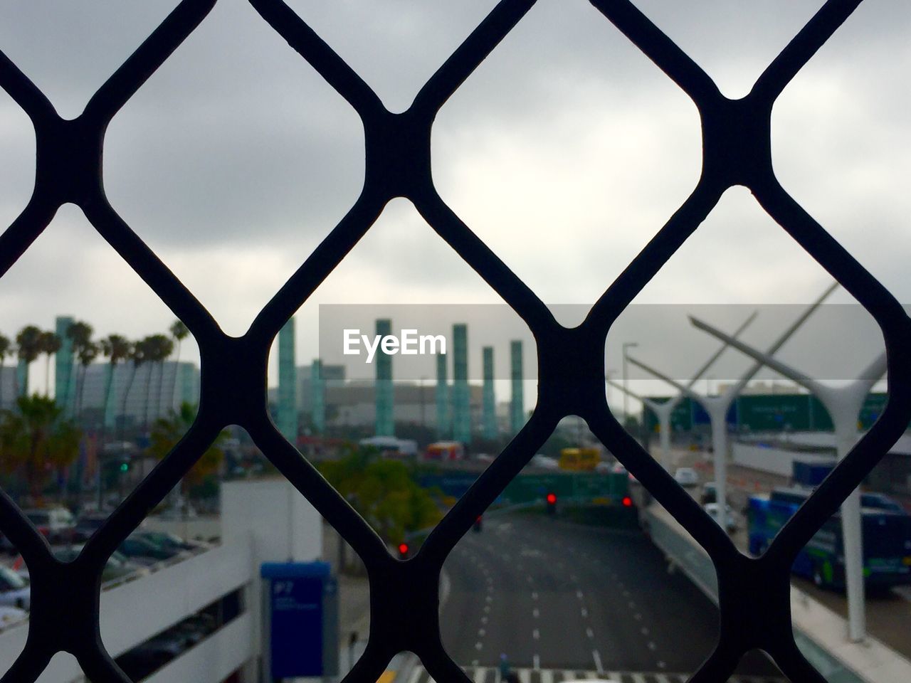 VIEW OF CITYSCAPE THROUGH CHAINLINK FENCE