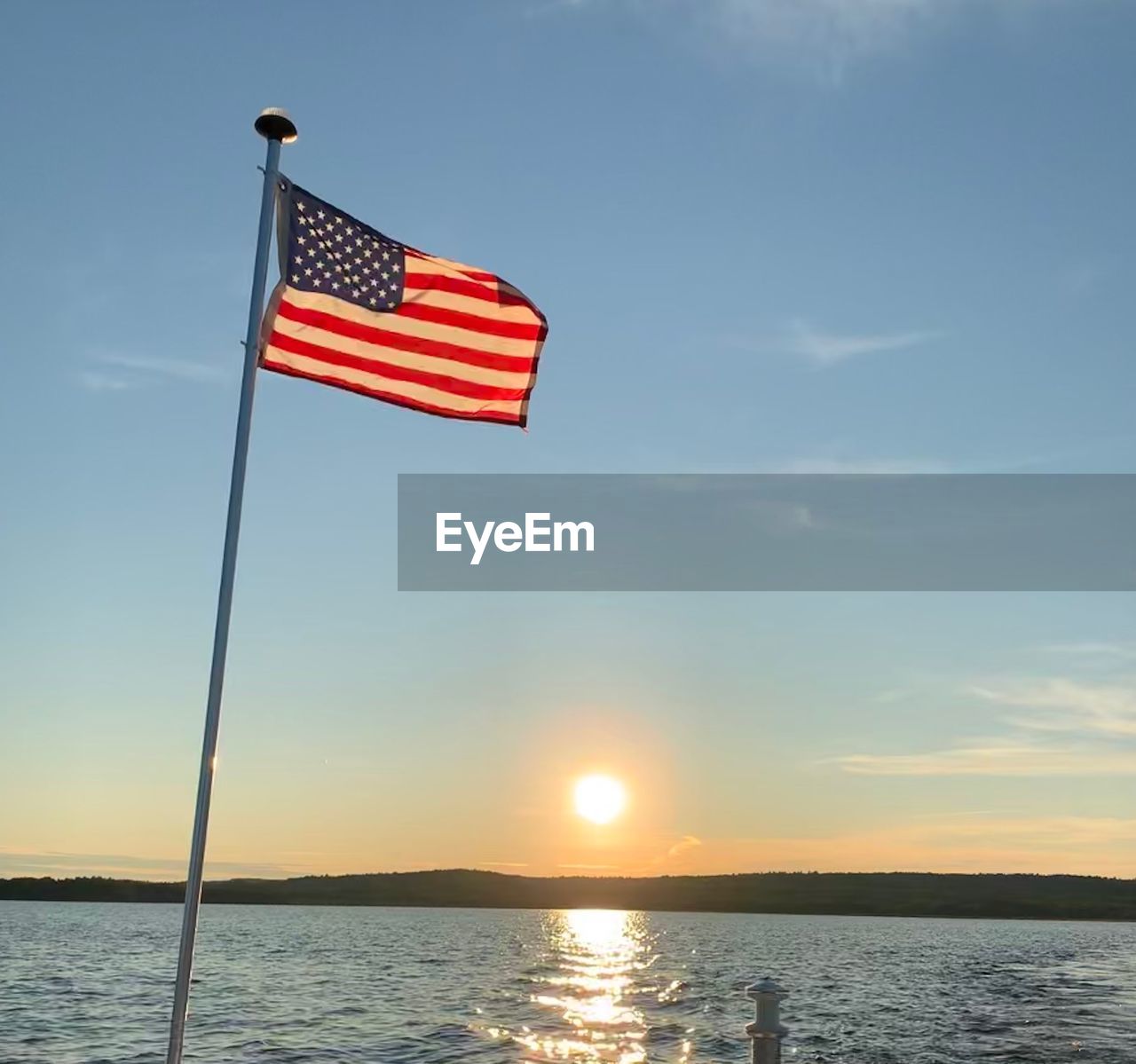 FLAG AGAINST SKY DURING SUNSET