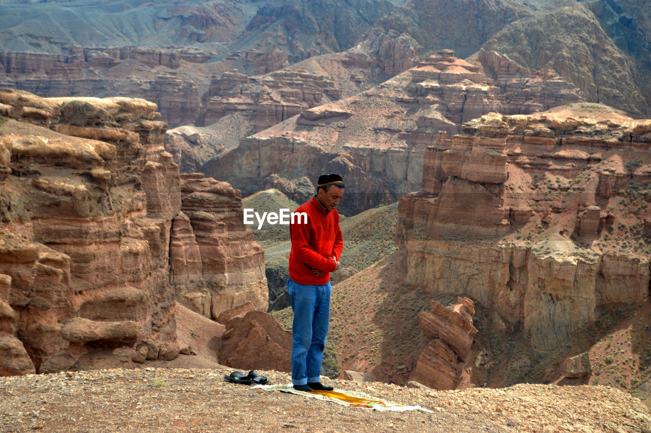 View of man praying in canyon