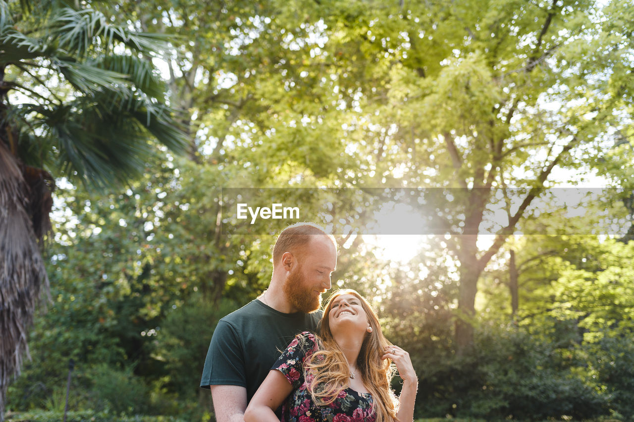 Redhead heterosexual couple smiling in park