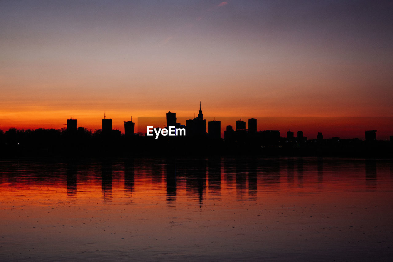 Silhouette buildings against sky during sunset