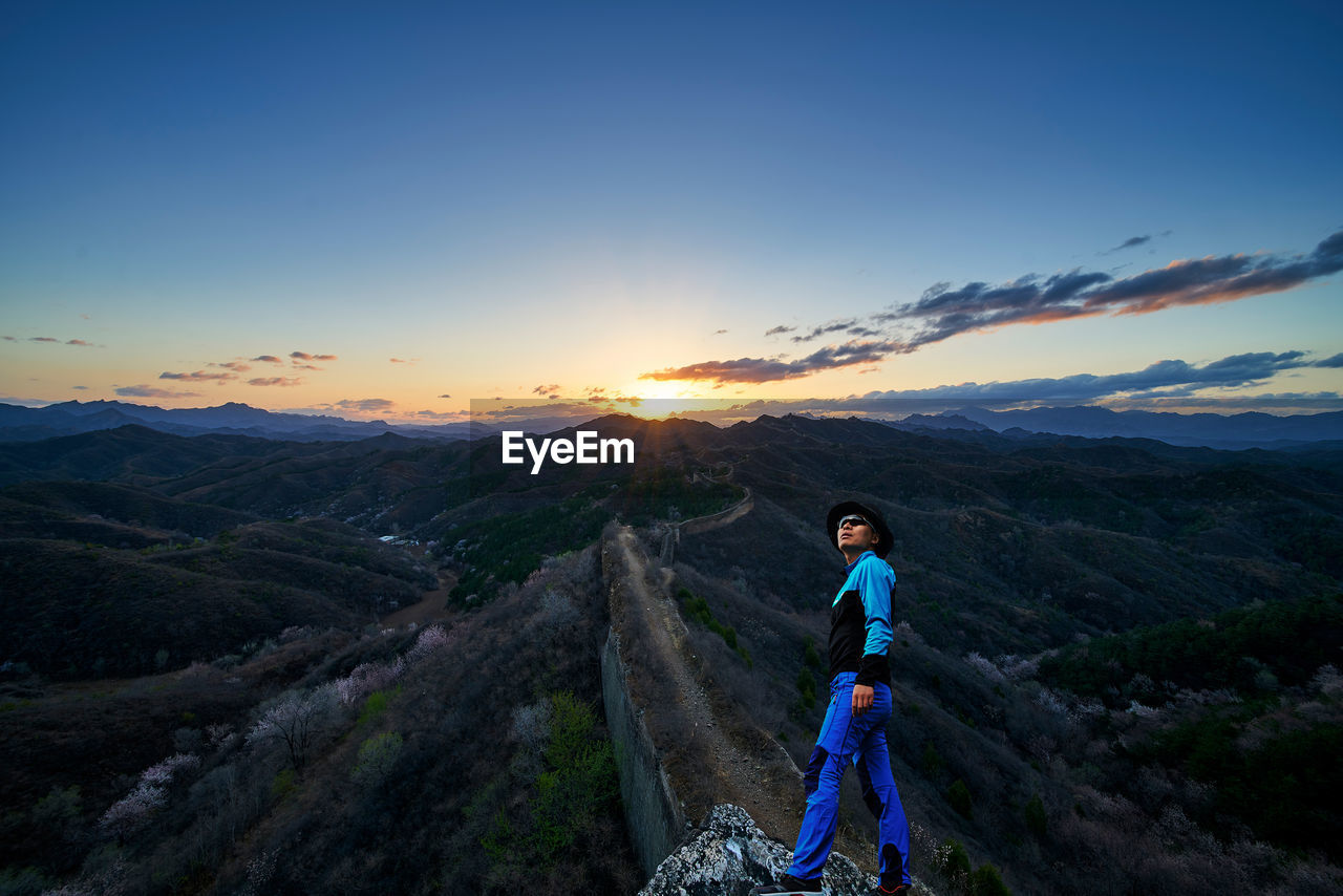 Man at great wall of china against sky during sunrise