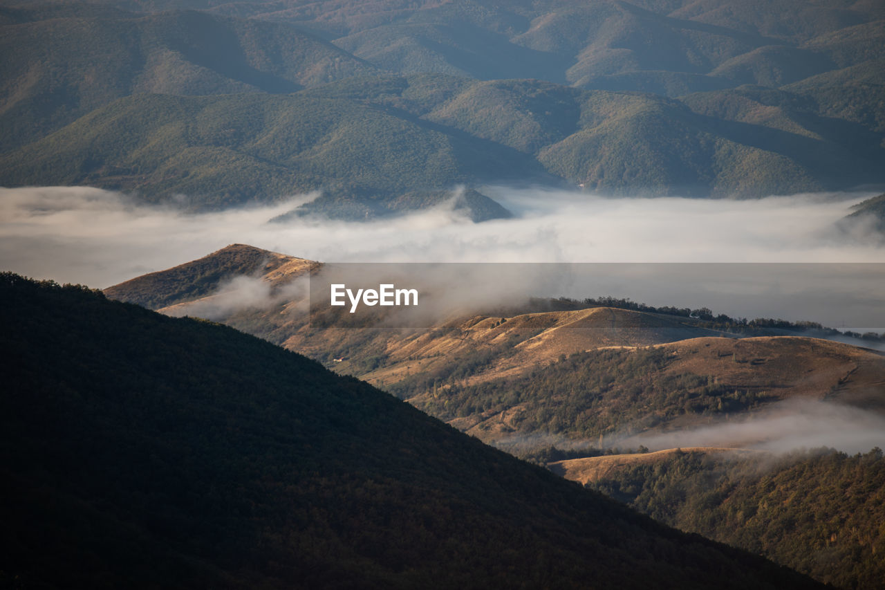 SCENIC VIEW OF MOUNTAINS AGAINST CLOUDY SKY